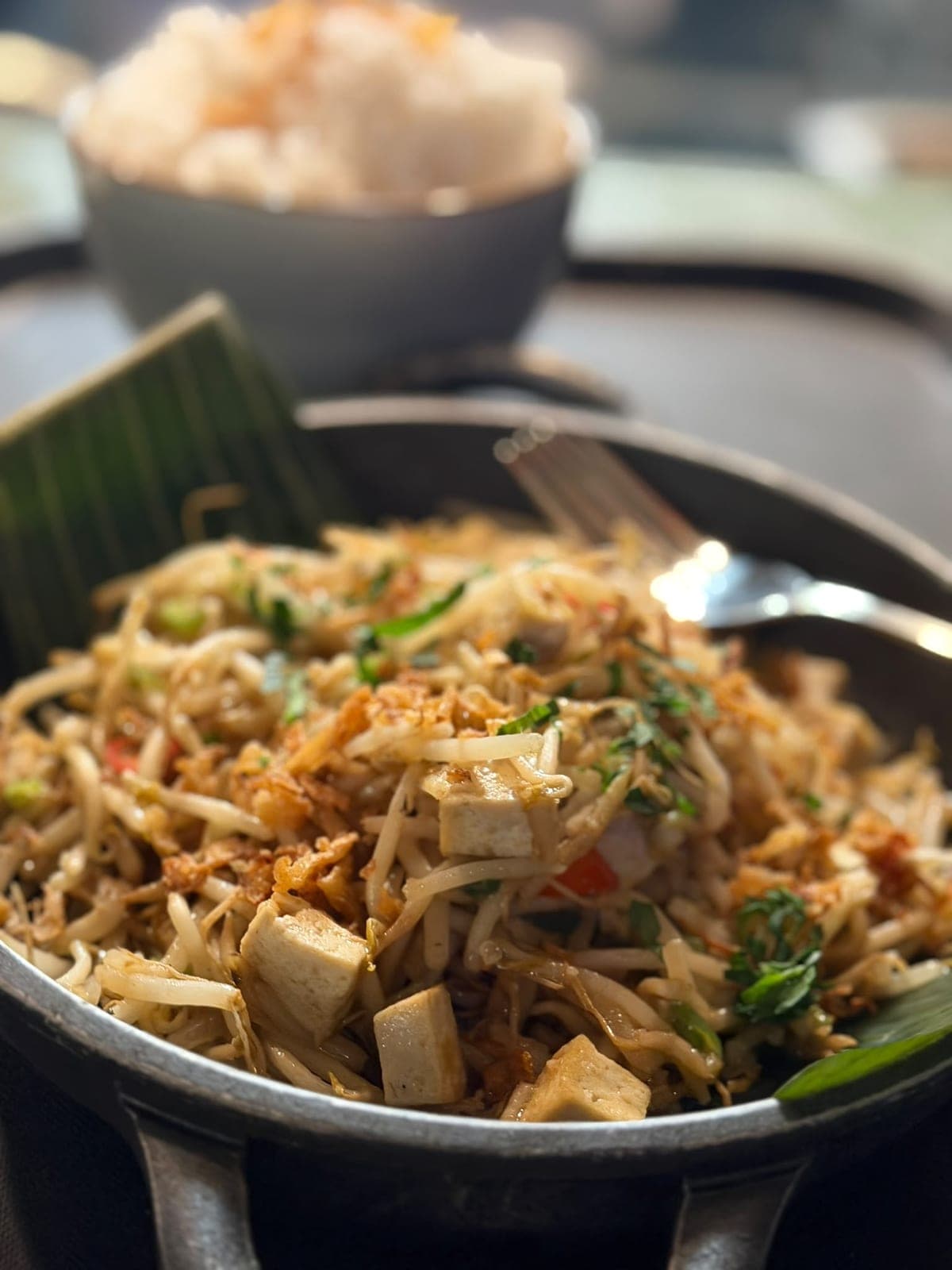 Gewokte noedels met tofu en taugé in een gietijzeren pan